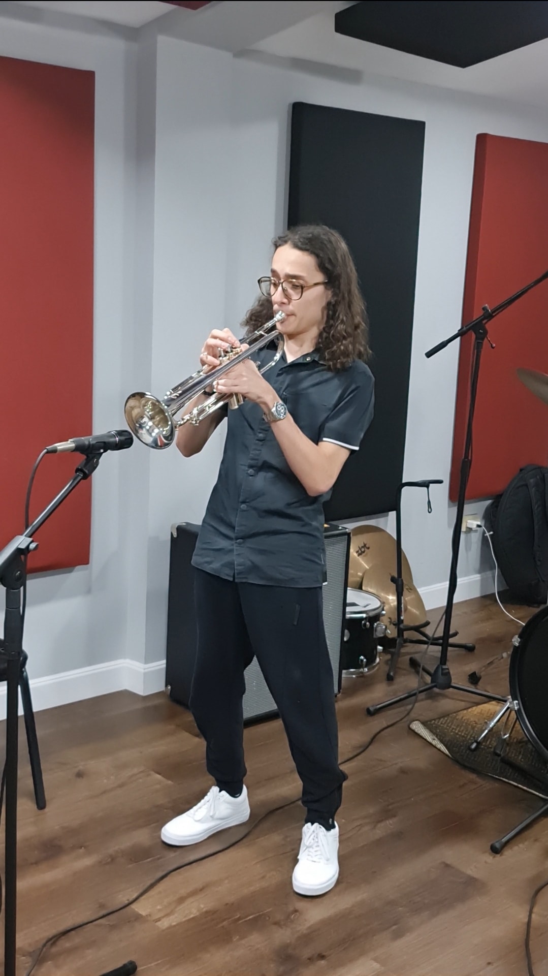 The Jammin House — trompetista en sala con paneles rojos