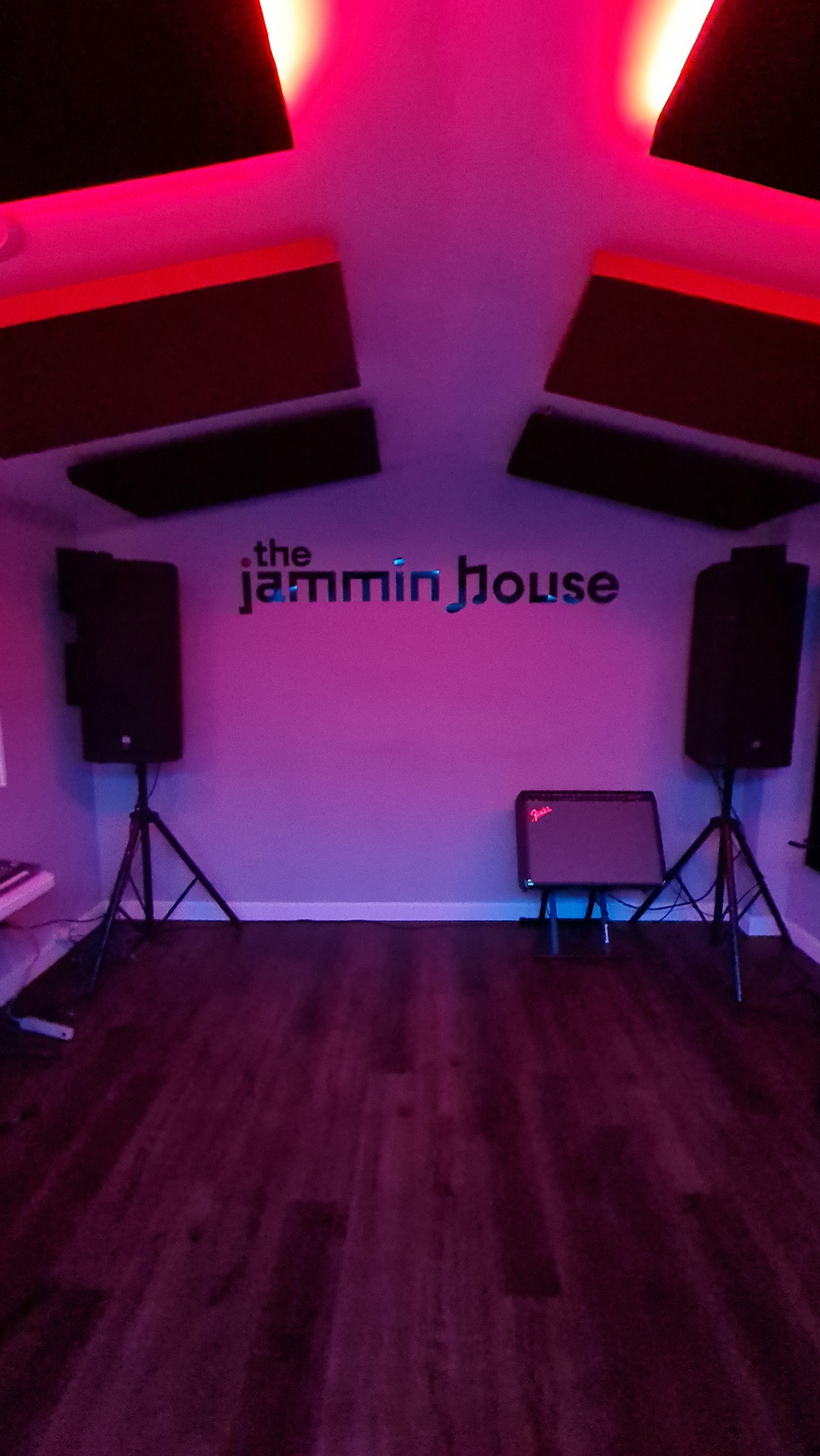 The Jammin House — sala con letrero y luces neón